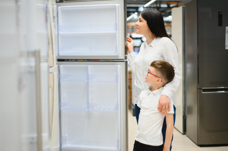 family choosing domestic refrigerator in supermarket.の写真素材