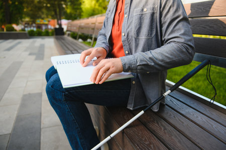 Blinded man reading by touching braille book.の写真素材
