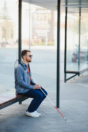 Blinded man waiting for bus at a bus station.の写真素材