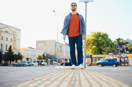 Handsome blind man walks around the cityの写真素材