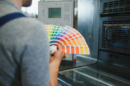 Man working in printing house with paper and paints.の写真素材