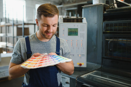 Man working in printing house with paper and paints.の写真素材