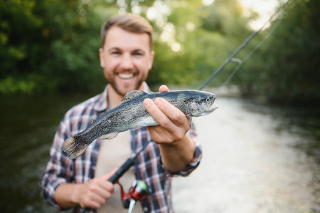 Young man flyfishing at sunrise.の写真素材
