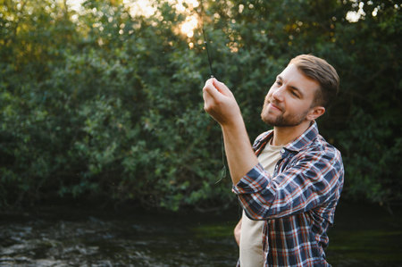 Young man flyfishing at sunrise.の写真素材
