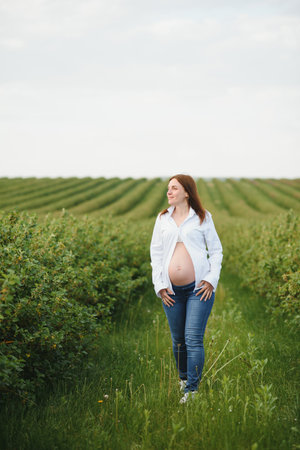 Beautiful pregnant woman relaxing outside in the park.の写真素材