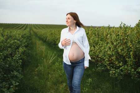 Beautiful pregnant woman relaxing outside in the park.の写真素材