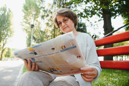 Portrait of a happy senior woman in summer park.の写真素材