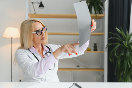 Portrait of middle age female doctor is wearing a white doctor's coat with a stethoscope around her...