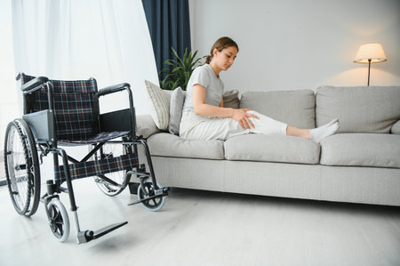 woman trying to sit down in wheelchair from couch.の写真素材