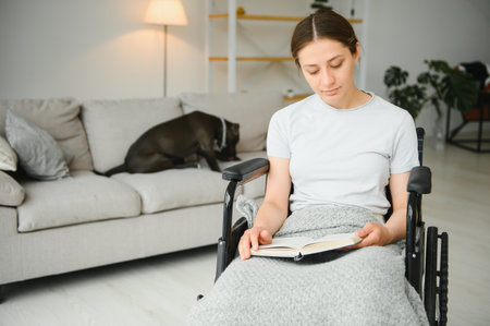 Young woman in wheelchair at home in living roomの写真素材