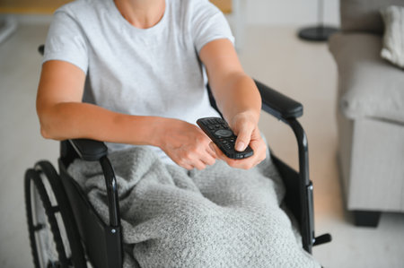 woman in wheelchair uses a tv remote control