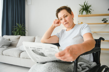 middle aged woman sitting on a wheelchair.の写真素材