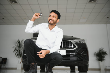 Indian man adult customer male buyer client wears classic suit white shirt chooses auto wants to buy new automobile touch check car in showroom vehicle salon dealership store motor show indoor. sales concept.の写真素材