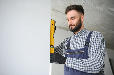 Laughing construction worker on the background of a gray concrete wall. renovation. place for text.の写真素材