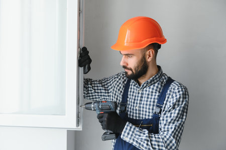 service man installing window with screwdriver.の写真素材