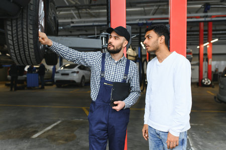 Mechanic, car servicing at garage - concept of timely customer service, car maintenance and deal agreemnetの写真素材