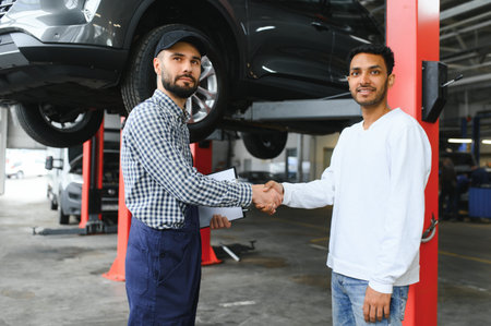 A mechanic in a car service is talking to an Indian car owner. car service conceptの写真素材