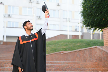 Portrait of indian handsome male graduate in graduation robeの写真素材