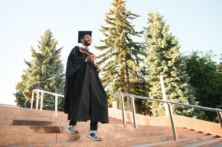 Young indian graduated boy holding his graduation degree convocation ceremony. student graduate...