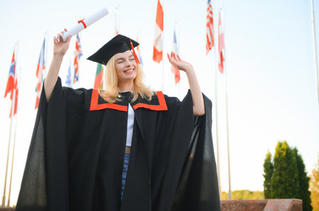 Happy university graduate girl. The girl is standing near the university against the background of...
