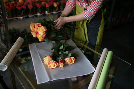 Young beautiful woman florist make bouquet of flowers at flower shop.の写真素材