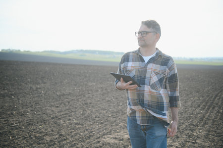 A farmer checks quality of soil before sowing