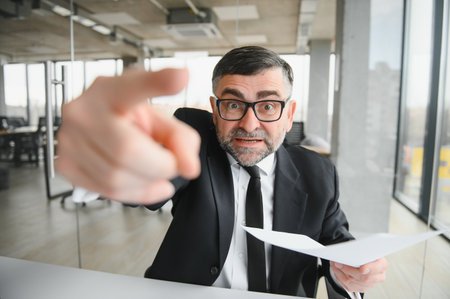 Angry businessman sitting at the table and screaming overの写真素材