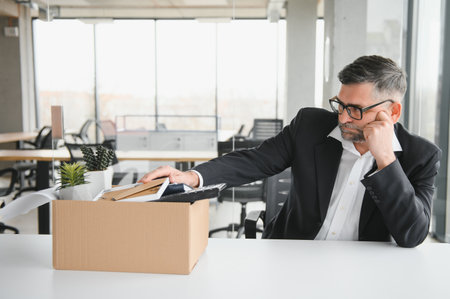 old employee leaving office with the box full of belongings.の写真素材