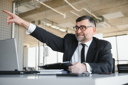 Angry businessman sitting at the table and screaming over