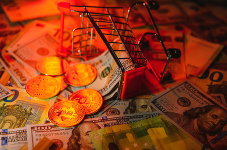 Close up heap of golden bitcoin physical coins on top of Euro, dollar banknotes background, high angle view, selective focus.の写真素材
