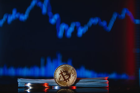 Golden bitcoins are stacked on a bright background of business graphs close-up. bitcoin cryptocurrency. Folded in a tube 100 dollar bills.の写真素材