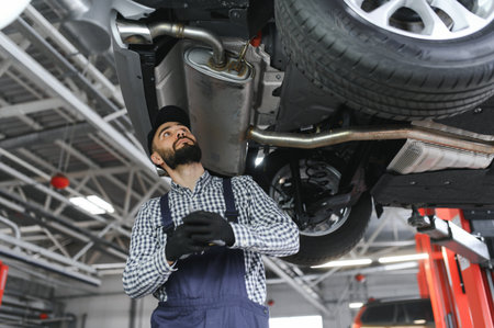Portrait of a mechanic repairing a lifted car.の写真素材