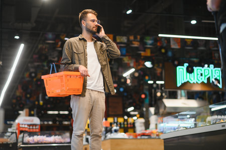Handsome man shopping in a supermarket.の写真素材