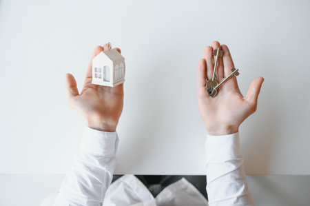 Real estate agent with house model and keys.の写真素材