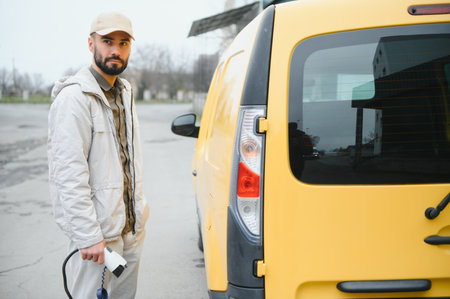 Man charging electric car by the work.の写真素材