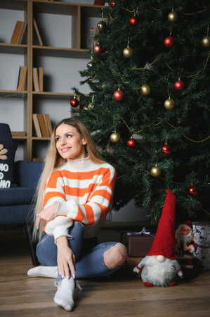 Beautiful young woman relaxing at home on Christmas day.