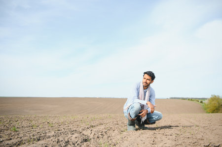 Young indian farmer standing at green turmeric agriculture field.の写真素材
