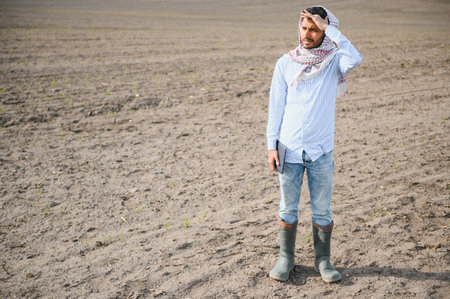 Young indian farmer standing at green turmeric agriculture field.
