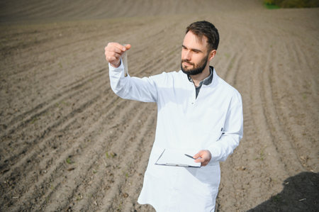 Agronomist studying samples of soil in the field.