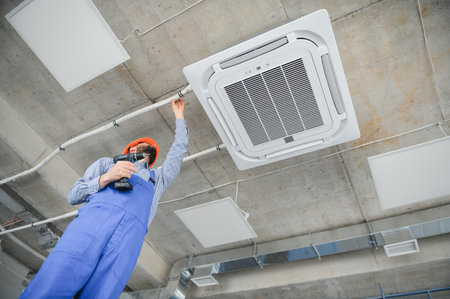 Happy Male Technician Repairing Air Conditionerの写真素材
