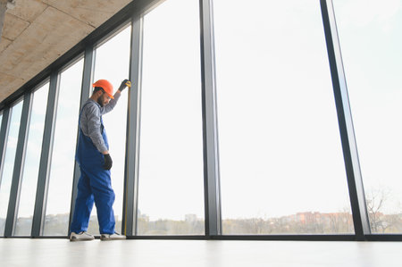 Worker installing plastic window indoorsの写真素材