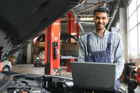 man car technician mechanic repairing car problem of engine, during system checking detail, using tablet computer for maintenance and fixing in car garageの写真素材