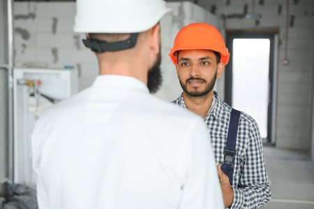 Happy workers at construction site, young civil engineer manager and architects. Indian and Arabian...
