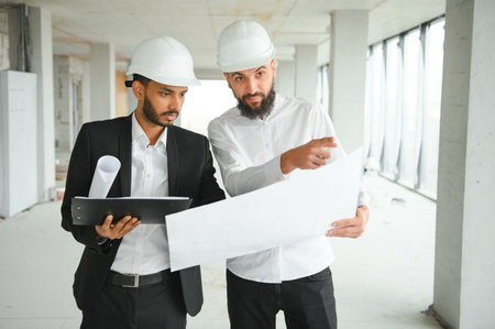 Indian and Arabian engineers. Contractor and architect talking about working on big project....