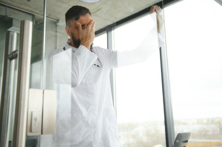 Portrait of exhausted tired young arab male doctor after hard day at work.の写真素材