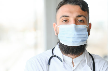 Portrait of pleasant young Arabian doctor in white coatの写真素材