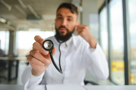 Portrait of pleasant young Arabian doctor in white coat