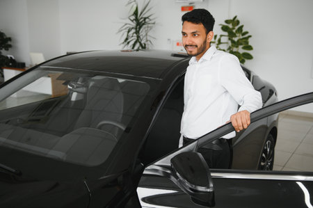 happy indian man buy new biodiesel eco automobile in lux showroomの写真素材