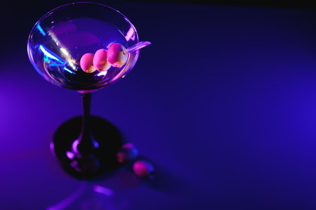 Glass of classic dry martini cocktail with olives on dark table against black background. With free space for your text.の写真素材