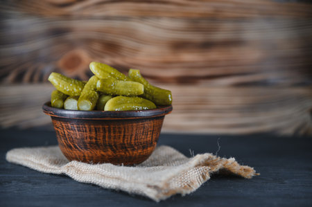 Pickled gherkins or cucumbers in bowl on wooden rustic table from aboveの写真素材